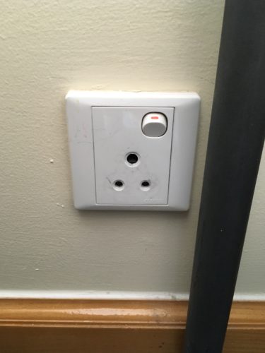 a white outlet with a switch on the wall