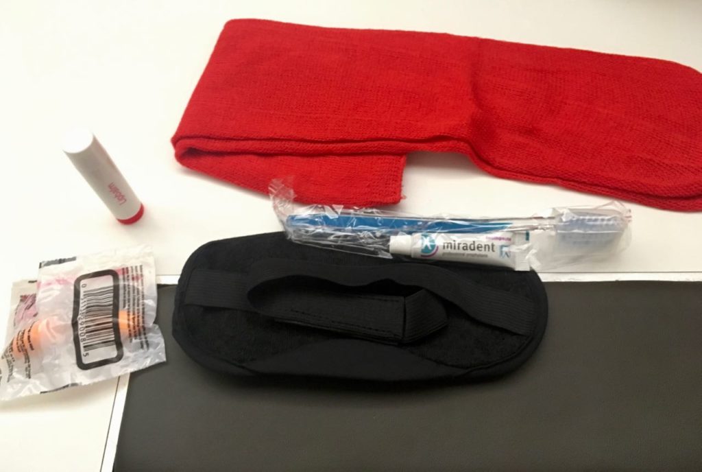 a red towel and a black towel next to a black towel and a toothbrush