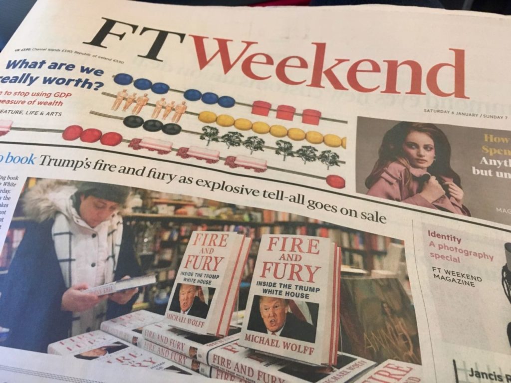 a newspaper with a picture of a man reading a book