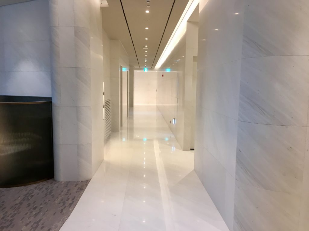 a hallway with white marble walls