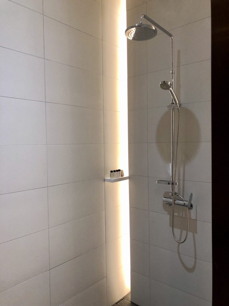 a shower with a light shining on the wall