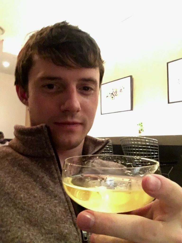 a man holding a glass of liquid