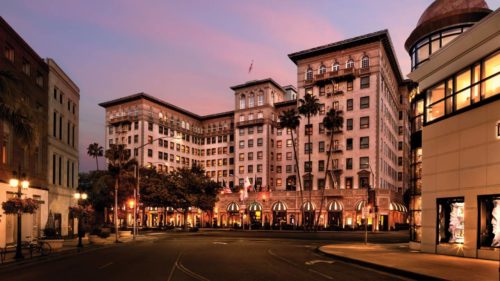 a large building with many windows with Beverly Wilshire Hotel in the background