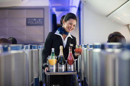 a flight attendant serving drinks