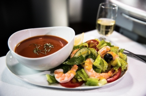 a plate of shrimp salad and a glass of wine