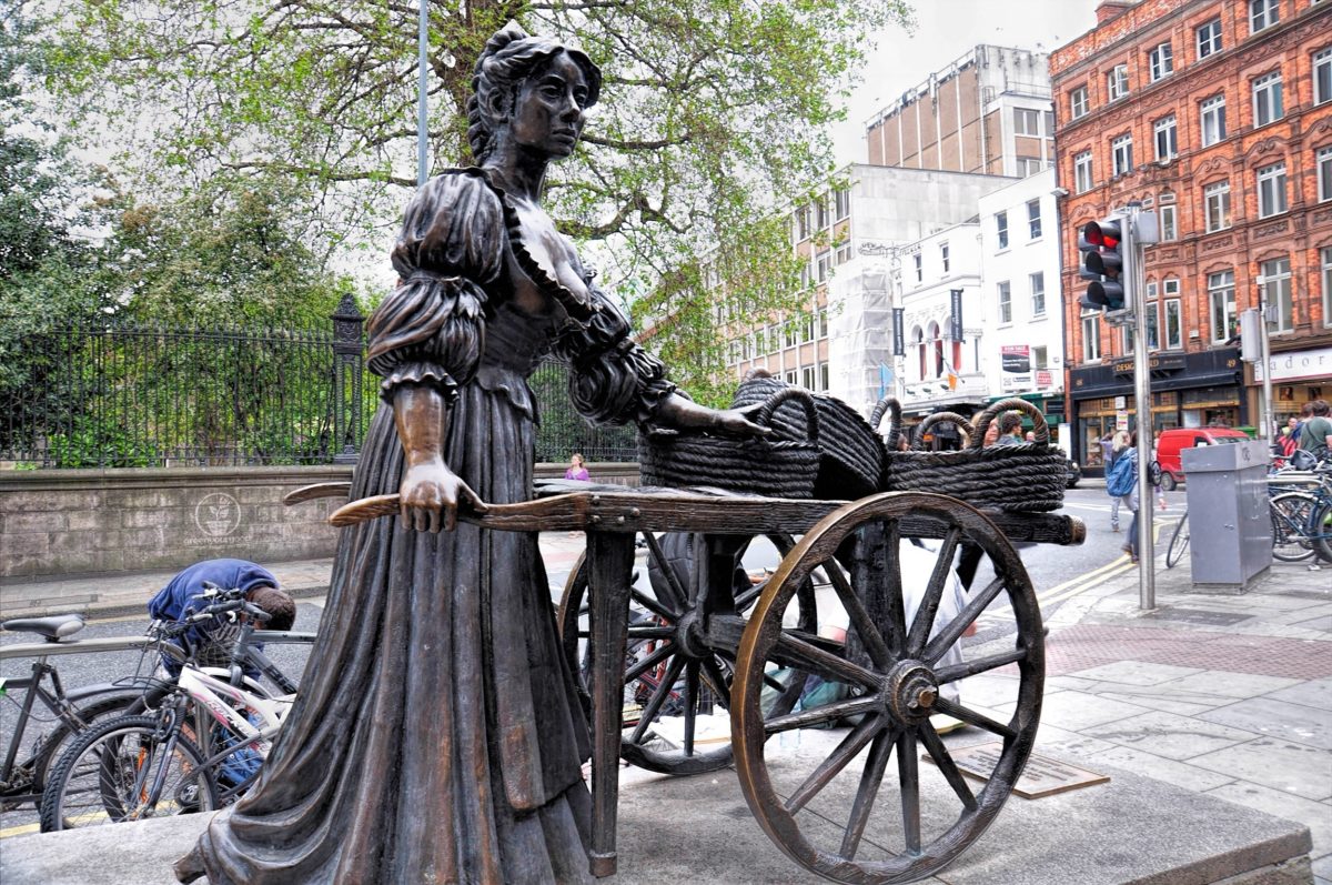 a statue of a woman holding a cart