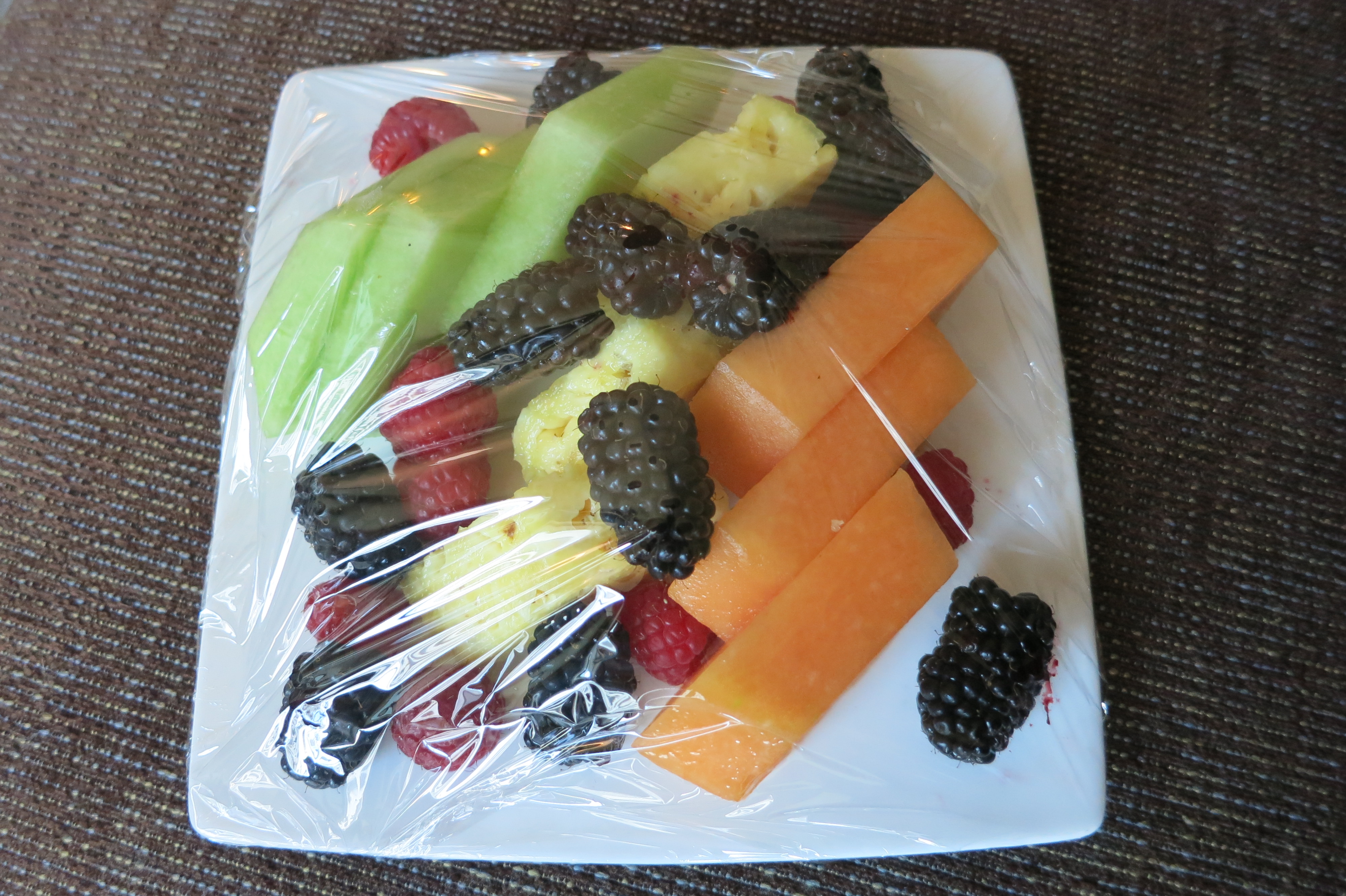 a plate of fruit wrapped in plastic