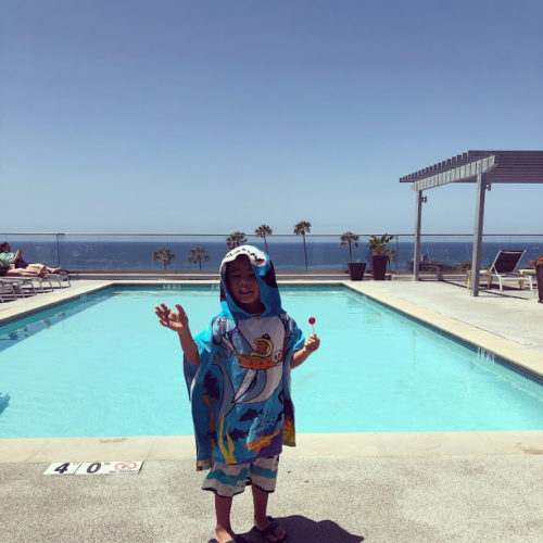 a child standing in front of a pool