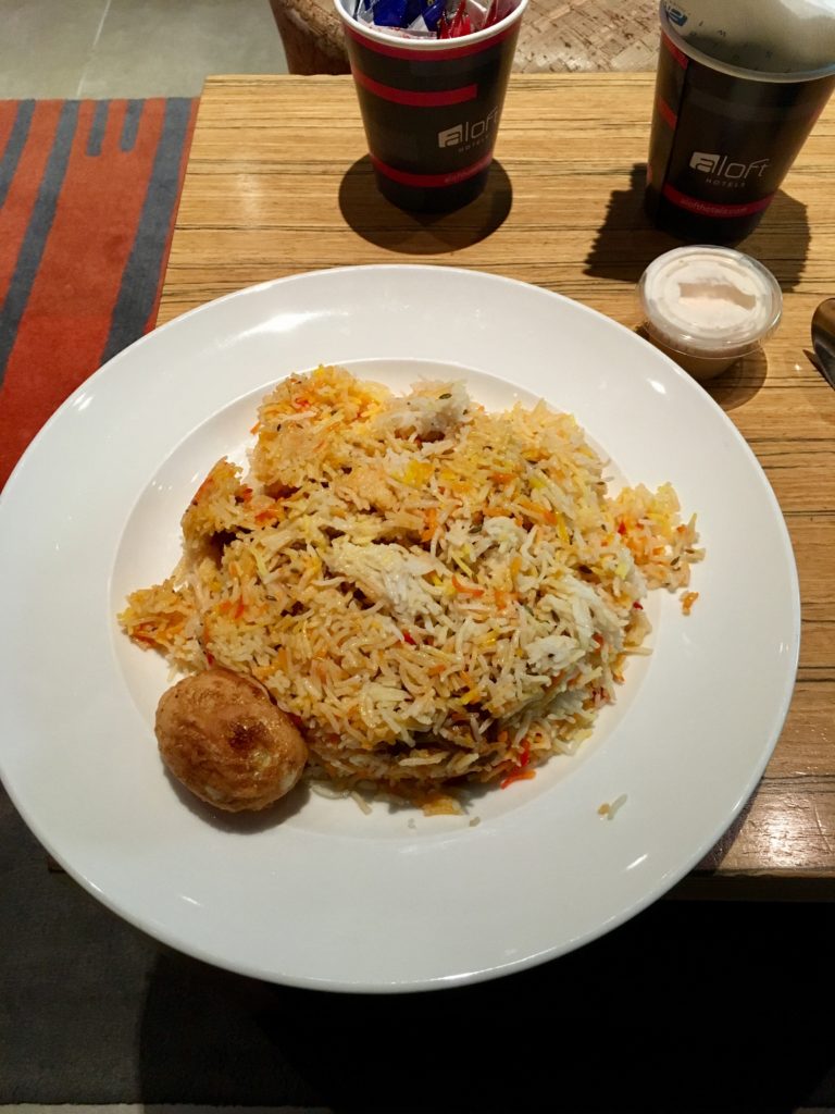 a plate of rice and meatballs on a table