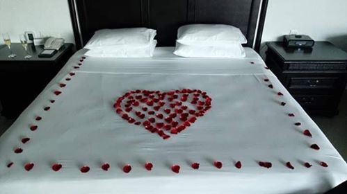 a bed with a heart made of rose petals