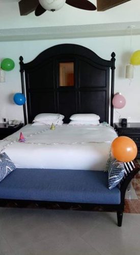 a bed with balloons and a chair