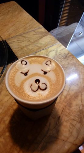 a cup of coffee with a face on the foam