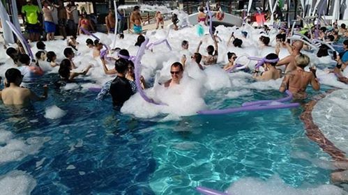 a group of people in a pool with foam