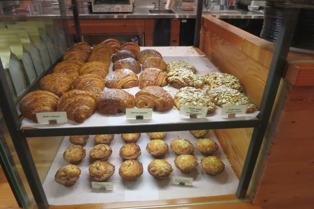 a display case with pastries and muffins