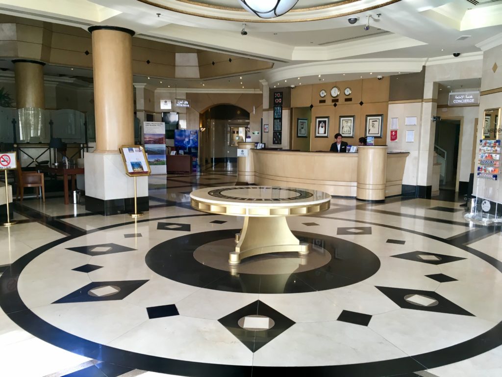 a lobby with a round table and a man standing behind it