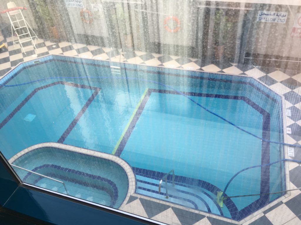 a pool with a tiled floor and a window