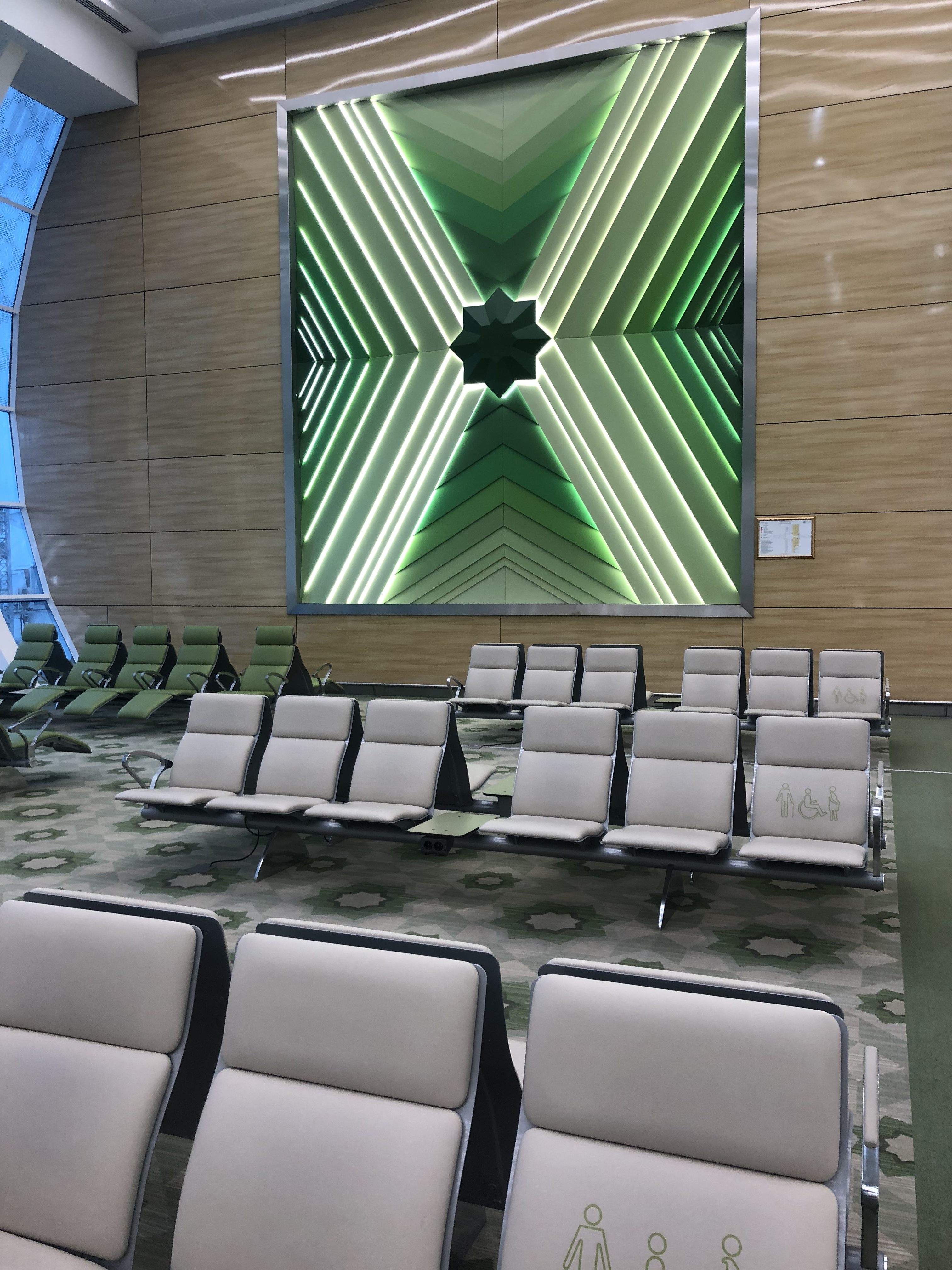 a large square picture of a green star on a wall with chairs