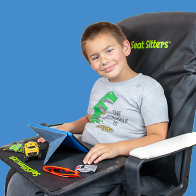 a boy sitting in a chair with a tablet