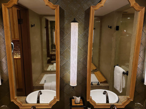 a bathroom with two mirrors and a light fixture