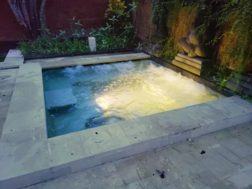 a small pool with a light shining on it