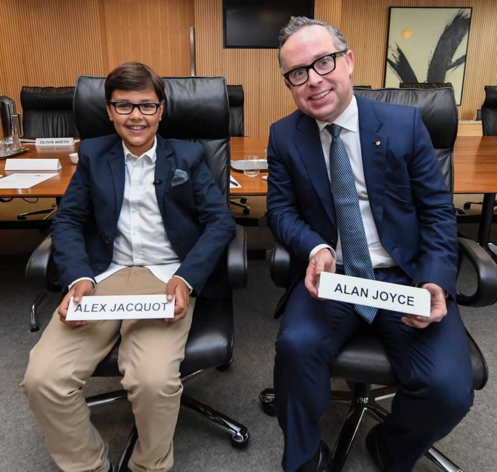 a man and boy sitting in chairs holding signs
