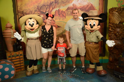 a group of people posing for a photo with mickey mouse characters