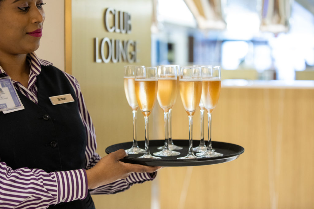 a person holding a tray of champagne glasses