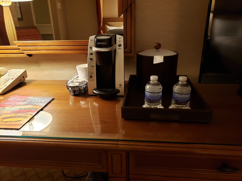a coffee maker and water bottles on a table