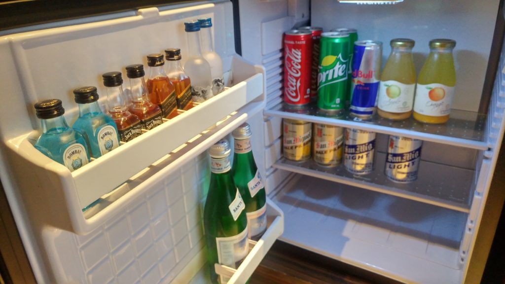 a refrigerator with bottles and cans of soda