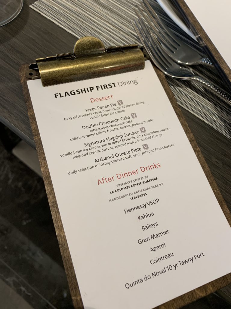 a menu on a clipboard with silverware on a table