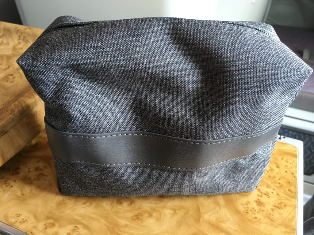 a grey fabric bag on a wood surface