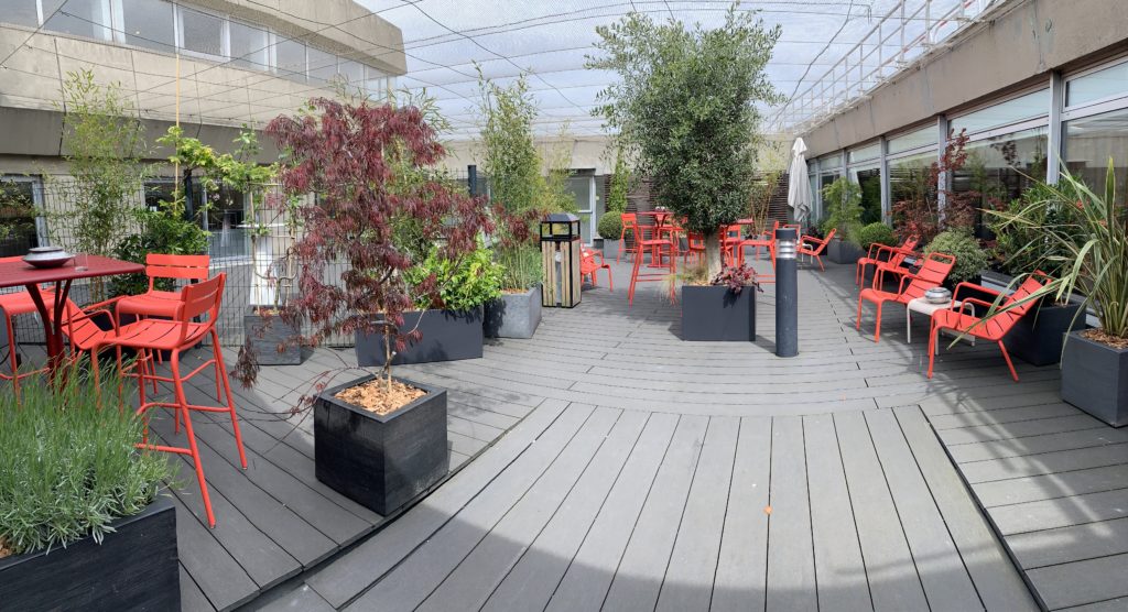 a patio with plants and chairs