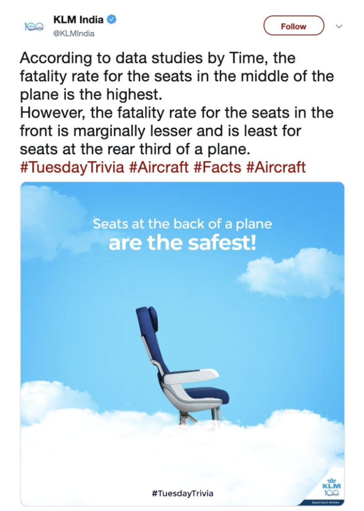 a blue and white airplane seat in the clouds