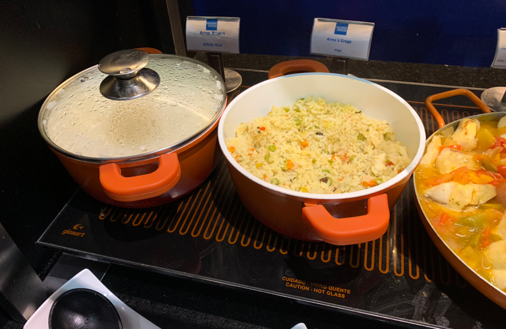 a two pots with rice and a lid on a stove
