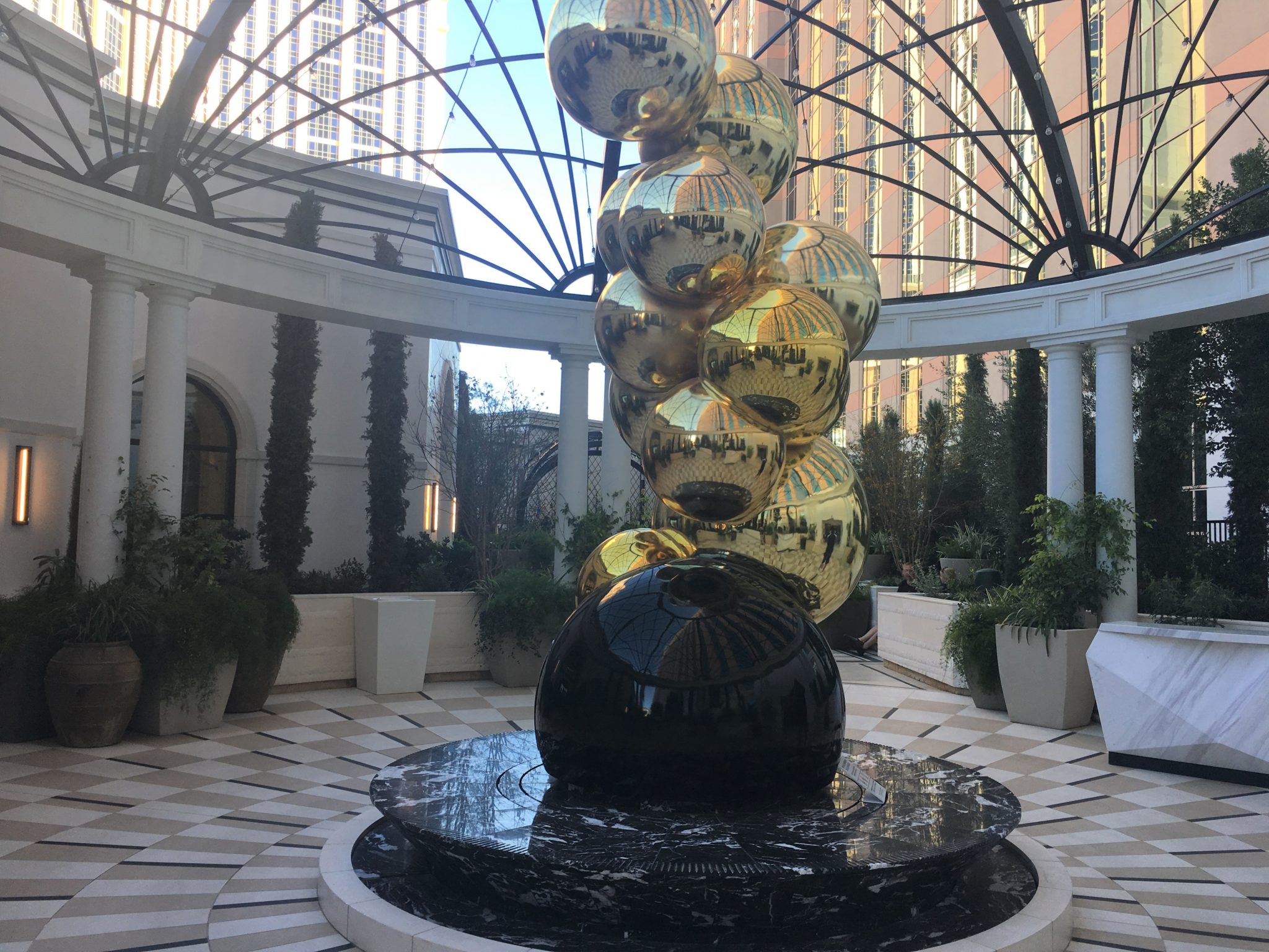 a large gold and black sculpture in a courtyard