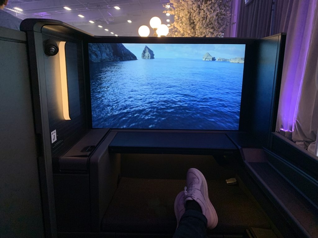a person's feet in a room with a large screen