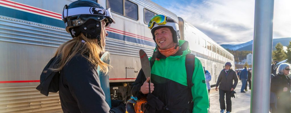 a man in a helmet and snowboard gear smiling at a woman