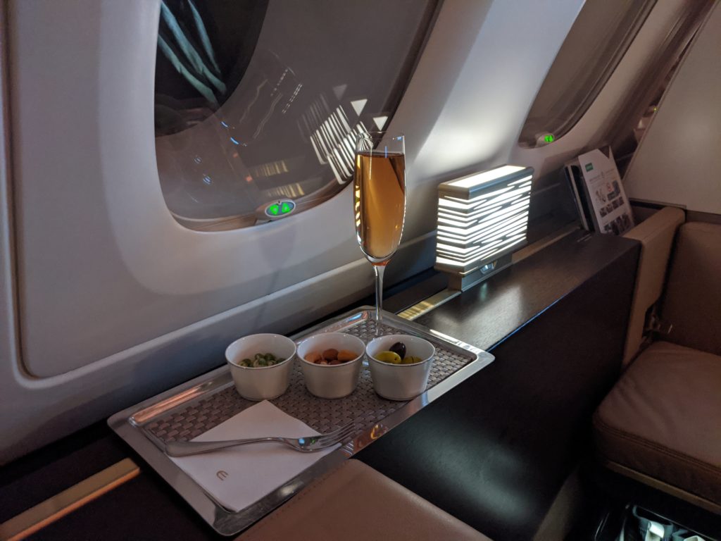 a glass of wine on a tray in a plane