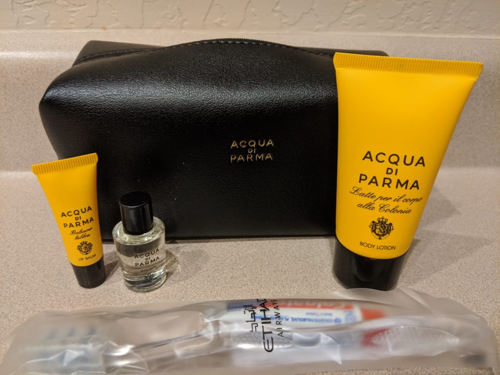 a black bag with a black case and a few small bottles of cosmetics