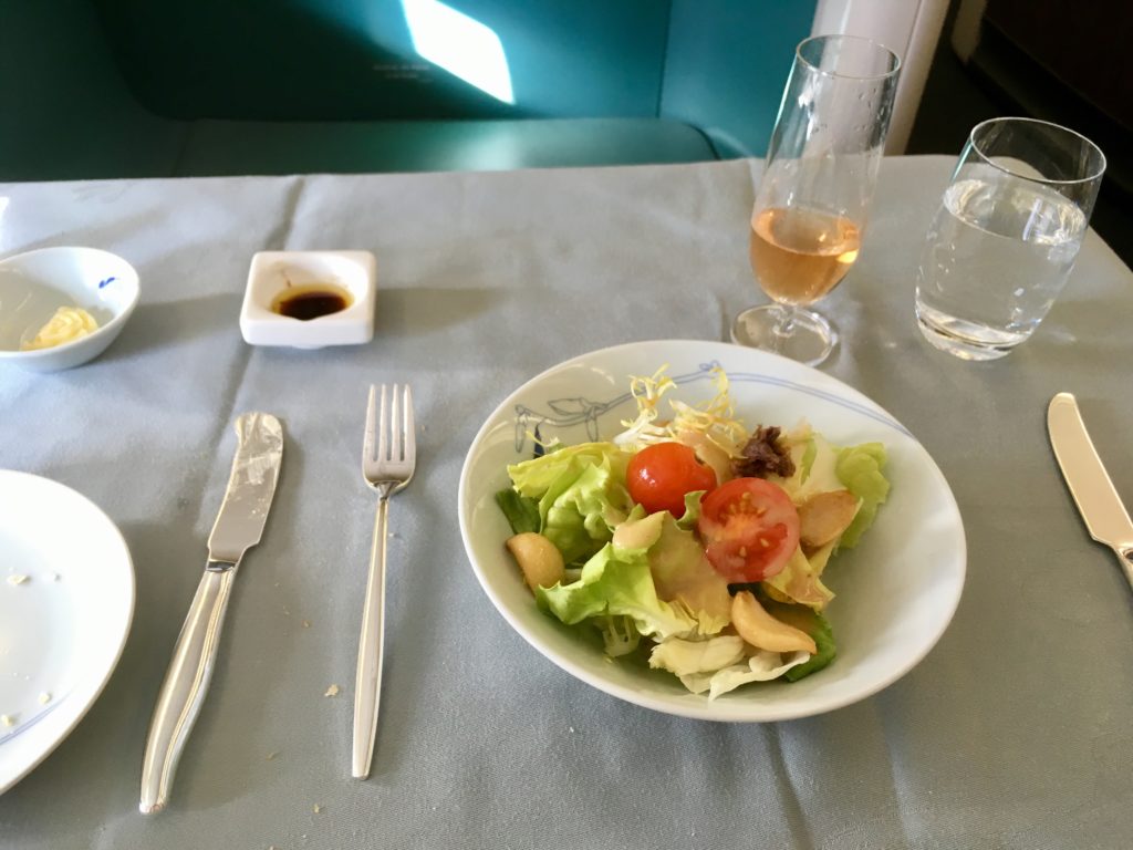 a plate of salad and a glass of wine