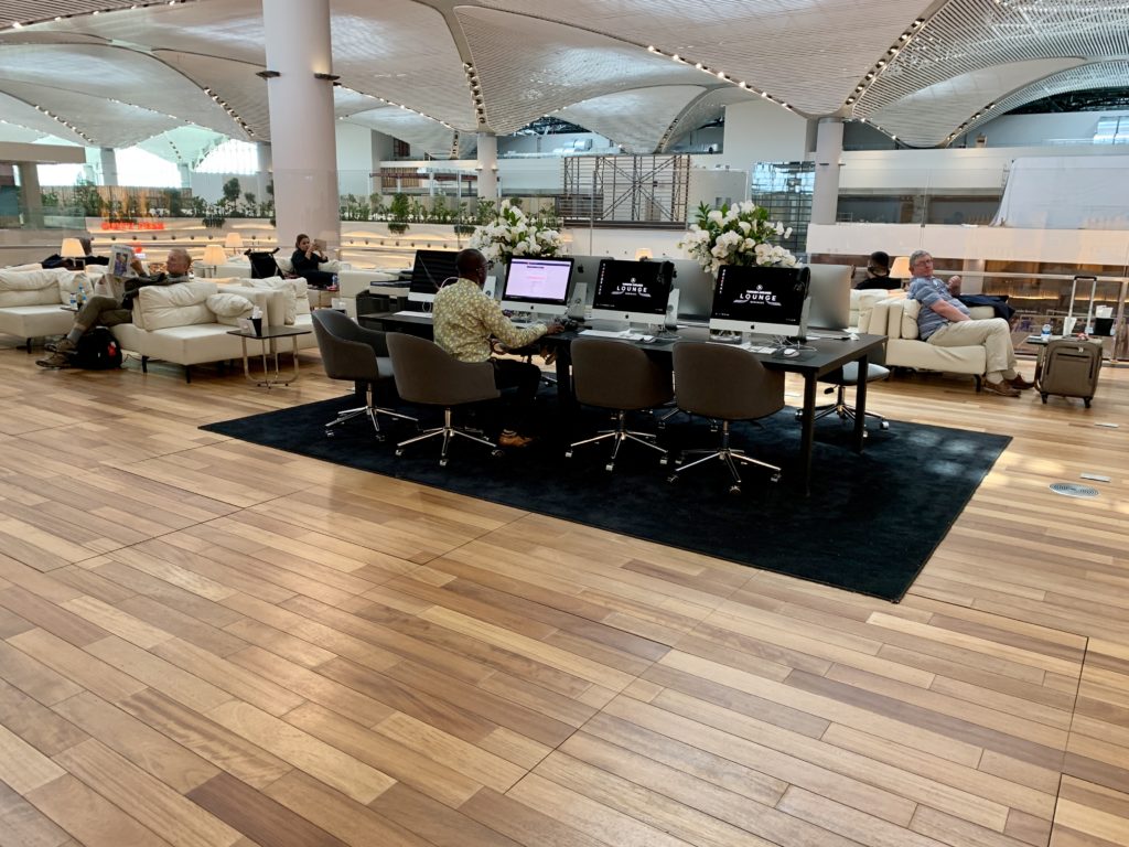a group of people sitting in chairs and a table with computers