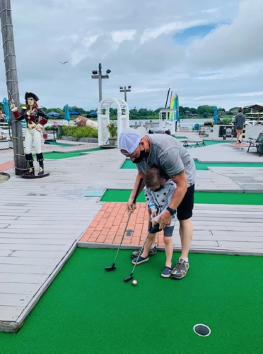 a man and child playing mini golf