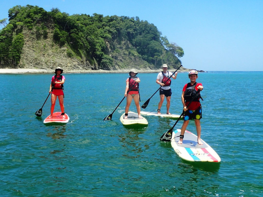 family paddleboarding to Isla Chora near Samara, Costa Rica