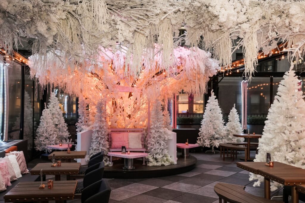 a room with white trees and pink lights