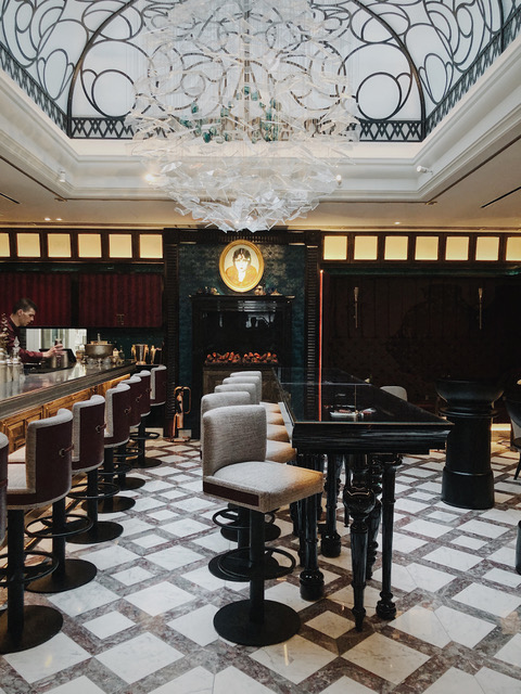 a bar with chairs and a chandelier