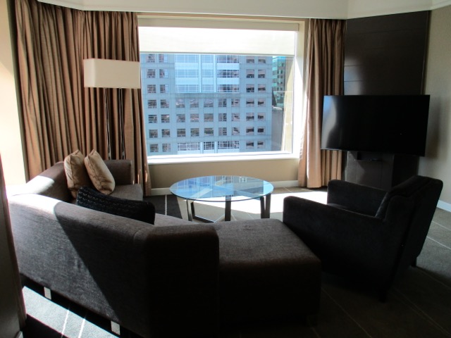 Grand Hyatt Melbourne Suite living room with television and couches
