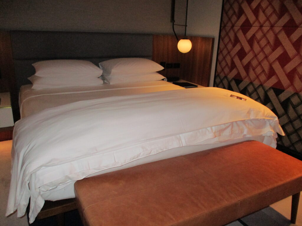 Park Hyatt Auckland suite bed with pillows and a lamp