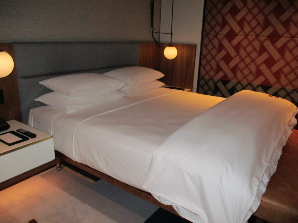 Park Hyatt Auckland bed with white sheets and a lamp