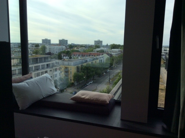Andaz Munich window with pillows and a view of a city